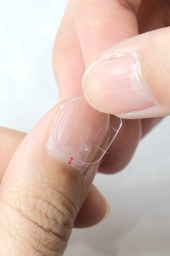 Stick the glue tabs around 1mm from the cuticles